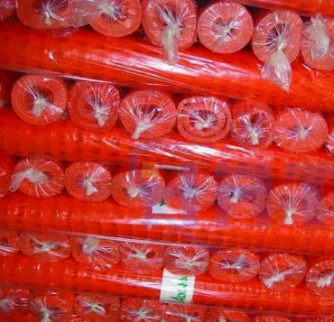 Red snow fences packed in stretched plastic film with label inside